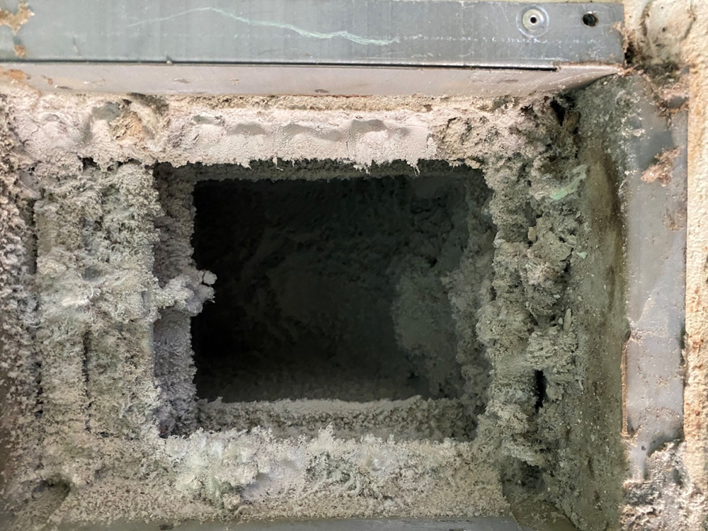 an extremely dirty and crusty dryer vent in a home's ductwork 